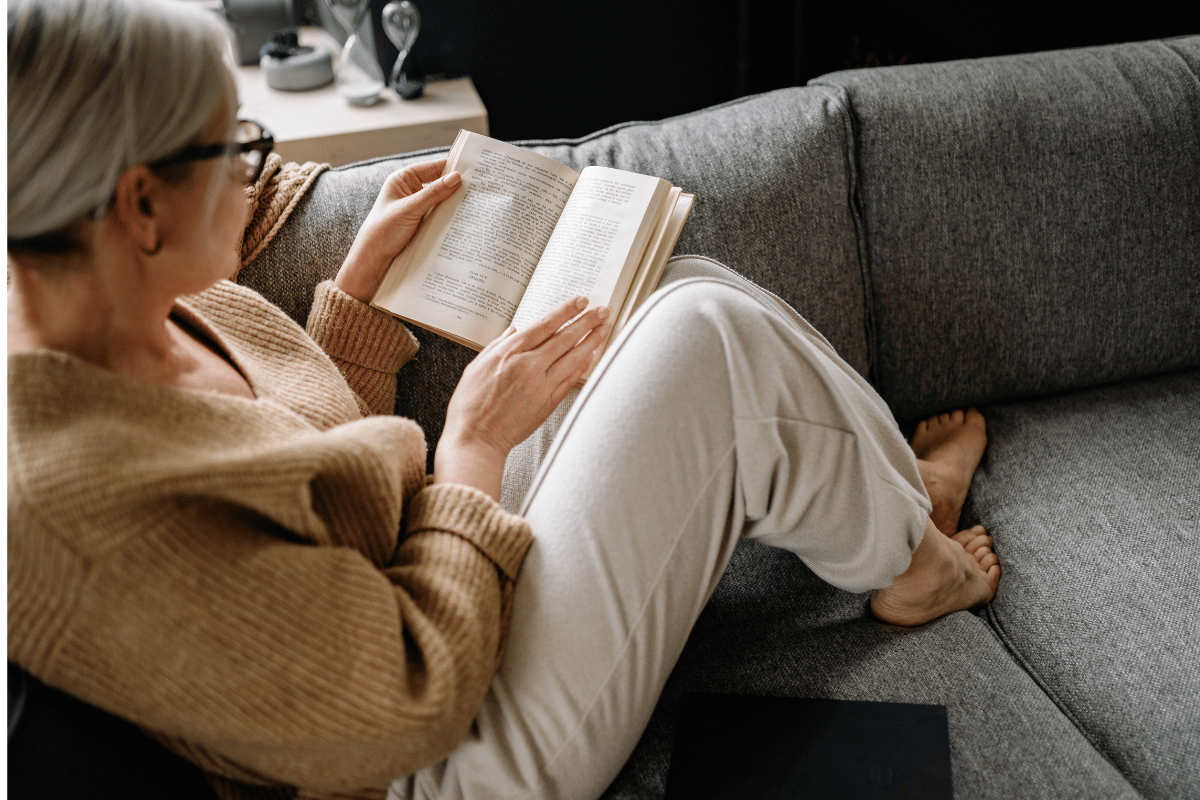 Schwierigkeiten beim Lesen bei Alterssichtigkeit Ältere Frau beim Lesen eines Buches bei Alterssichtigkeit